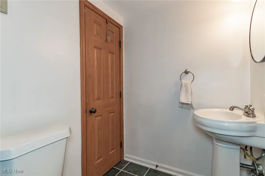 Bathroom featuring dark tile patterned floors and baseboards