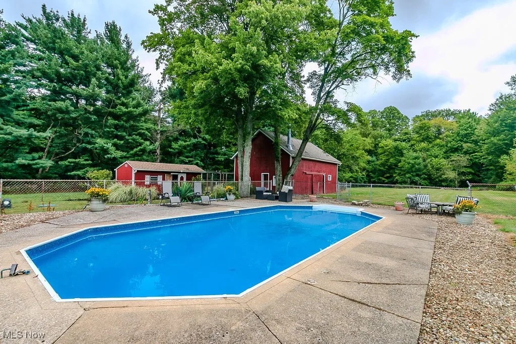 View of pool featuring an outbuilding, a fenced backyard, and a patio