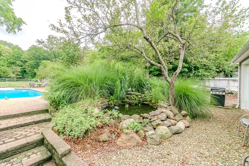 View of yard with a garden pond and a patio