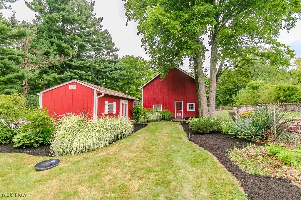 View of yard featuring an outbuilding and view of wooded area