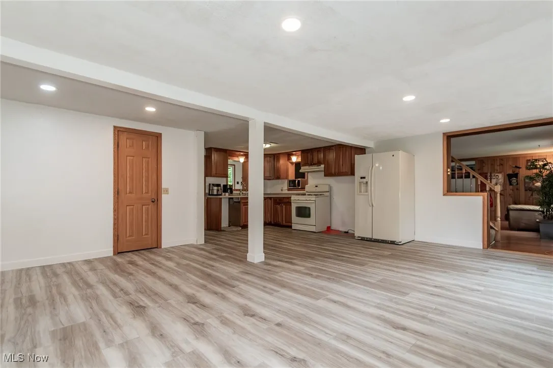Unfurnished living room with recessed lighting, light wood-type flooring, and stairs