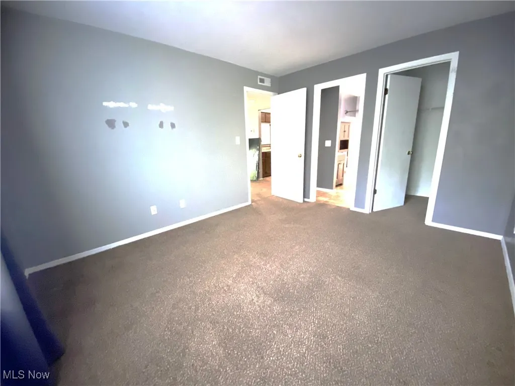 second bedroom with carpet and direct access to full bath and walk in closet