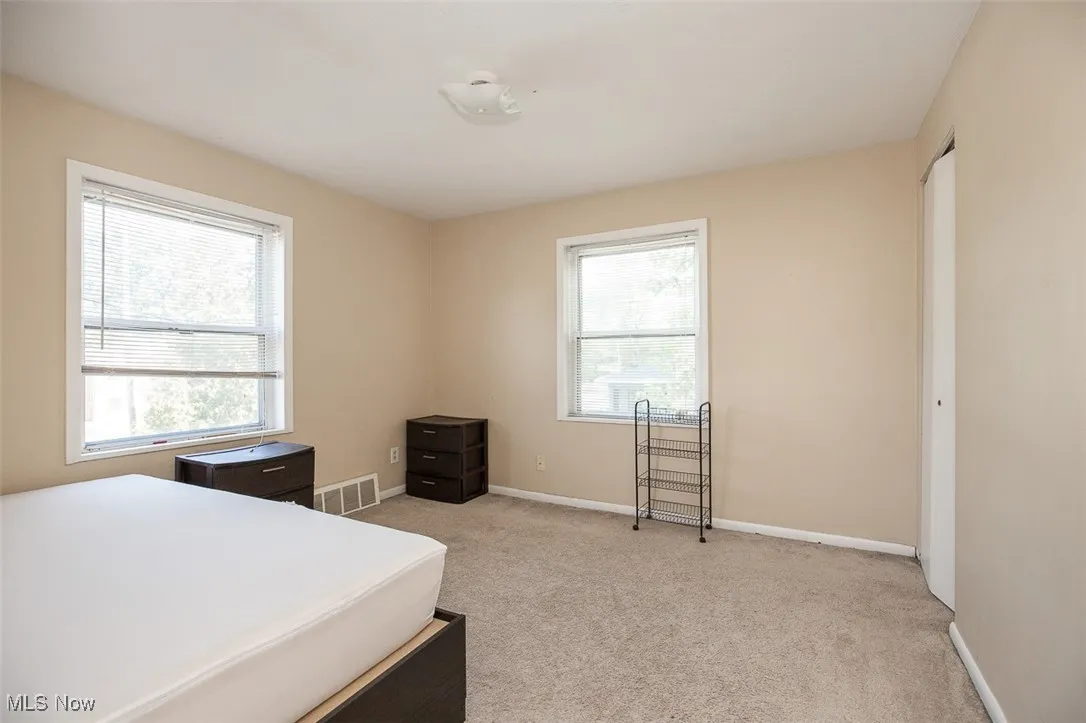 Bedroom featuring light carpet and baseboards