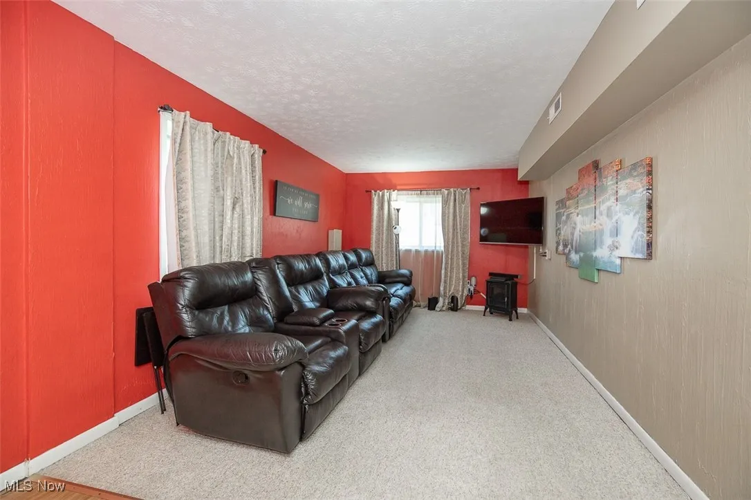 Living area featuring light carpet and a textured ceiling