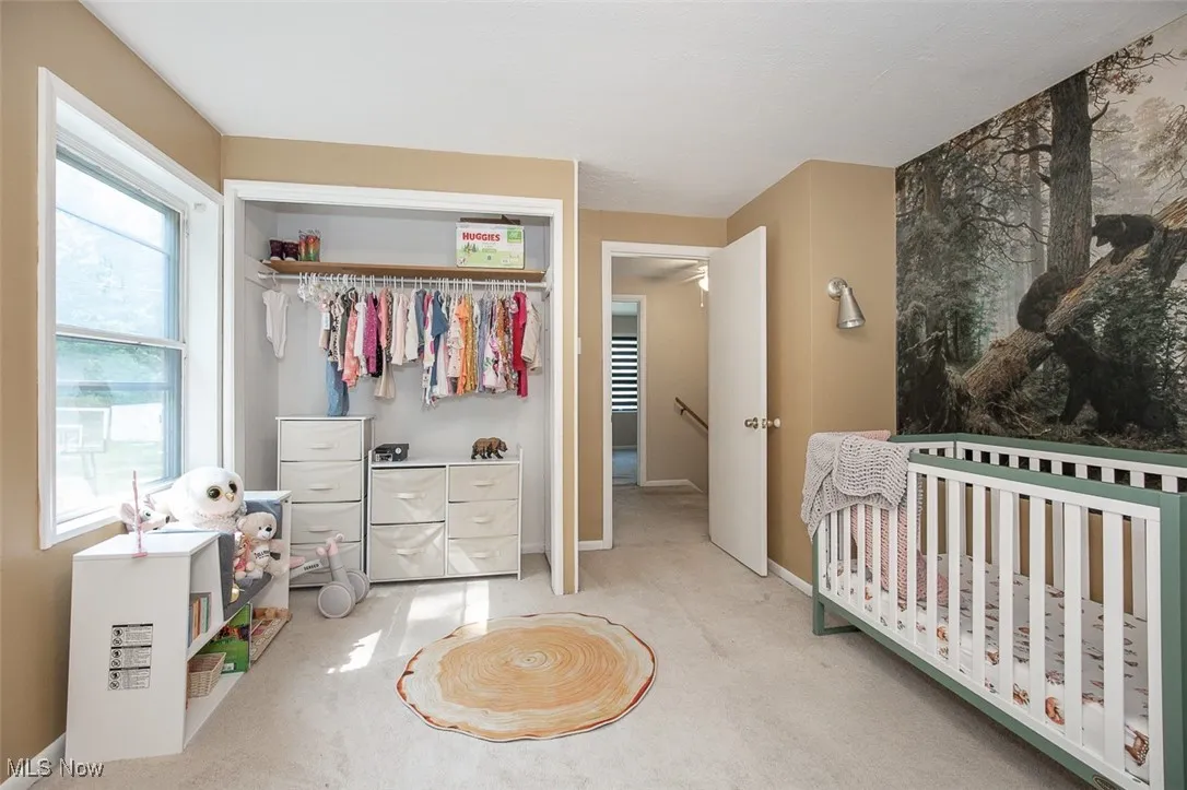 Carpeted bedroom featuring a closet and a crib