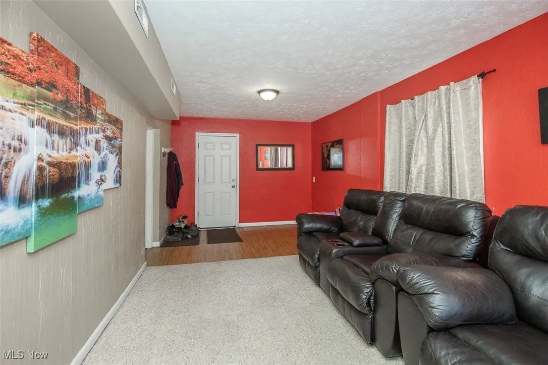 Living area featuring carpet and a textured ceiling