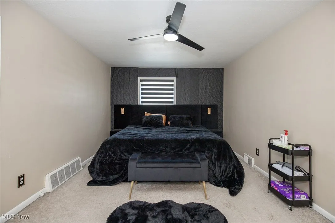 Carpeted bedroom with baseboards and ceiling fan