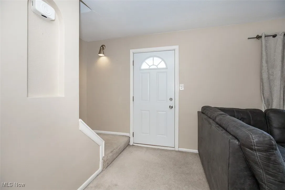 Entrance foyer with carpet floors and baseboards