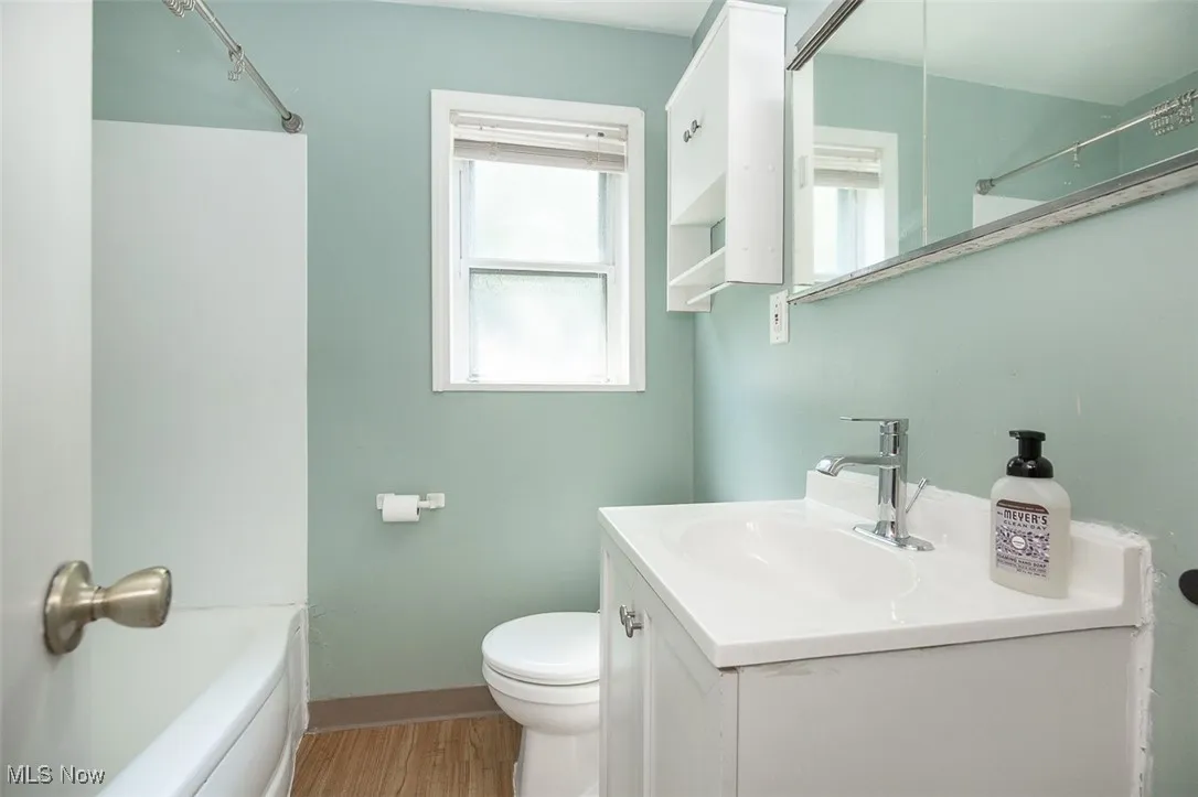 Bathroom featuring vanity, light wood finished floors, and shower / washtub combination