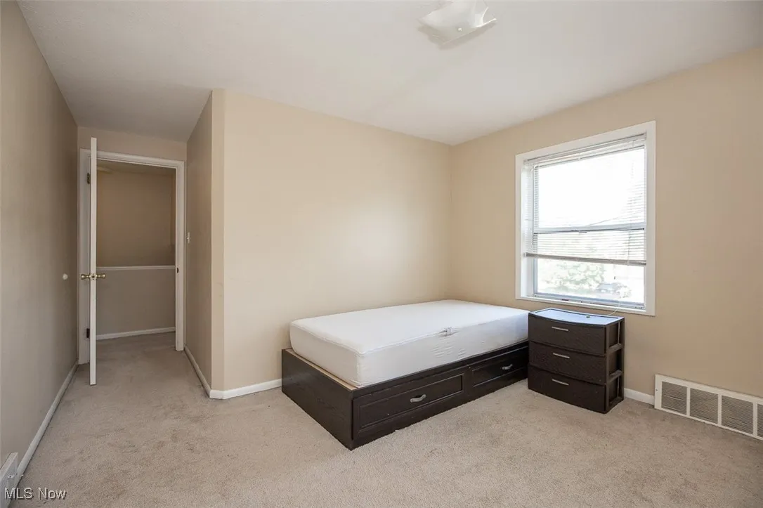 Bedroom featuring light carpet and baseboards