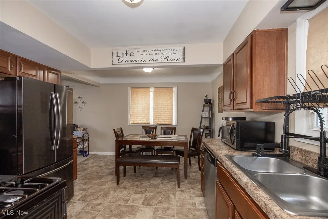 Kitchen featuring appliances with stainless steel finishes and brown cabinets