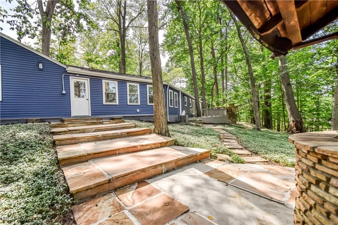Entrance to property with a wooden deck and view of scattered trees