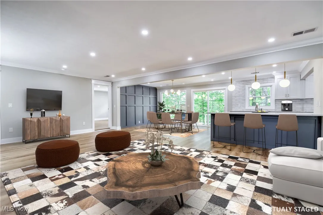 Living area featuring ornamental molding, recessed lighting, and light wood-style floors