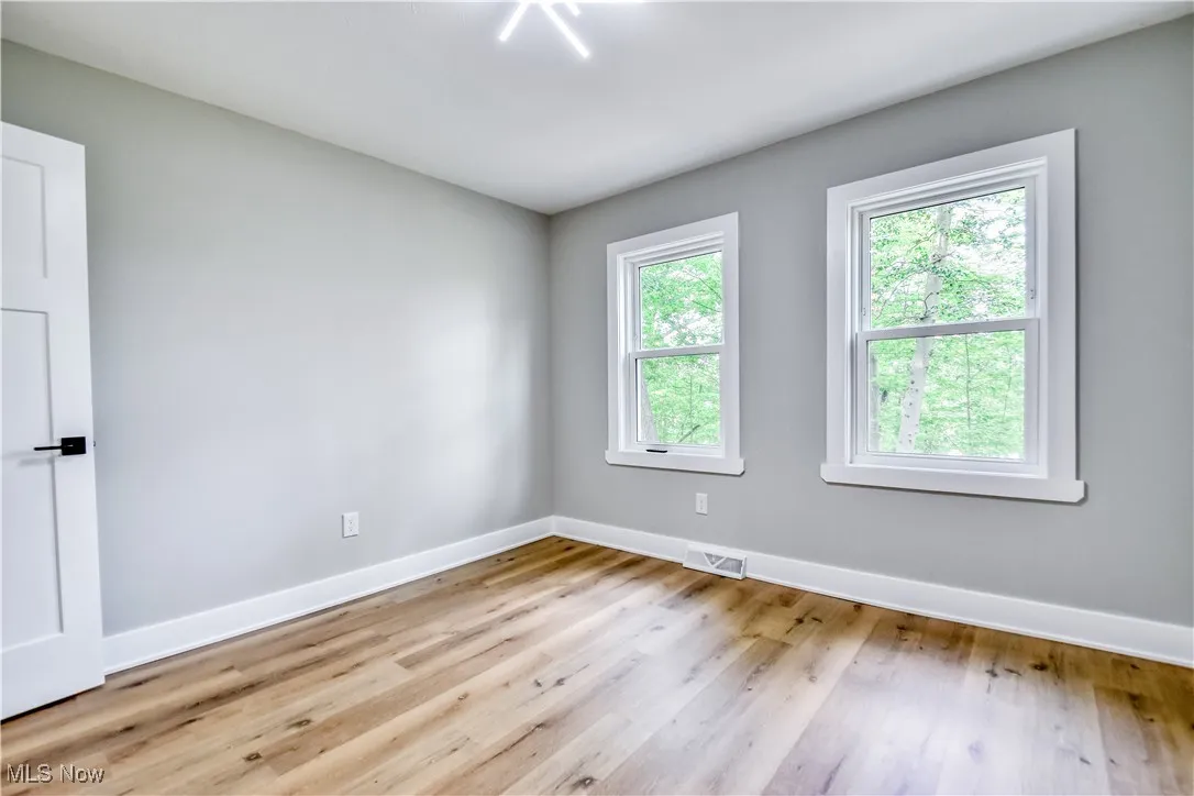 Empty room with baseboards and light wood-style floors