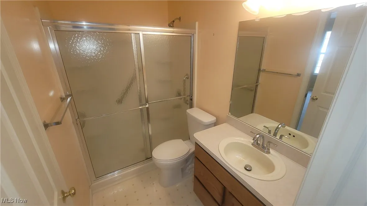 Full bathroom featuring vanity, a stall shower, and light floors