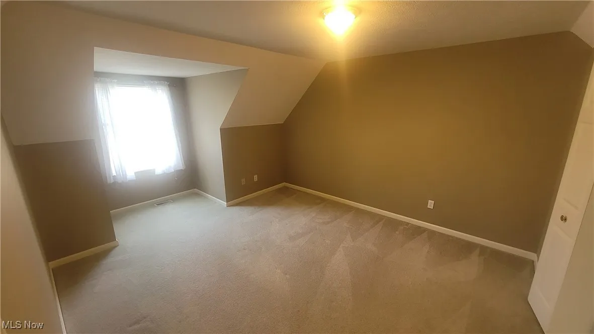 2nd floor bedroom featuring lofted ceiling and light carpet