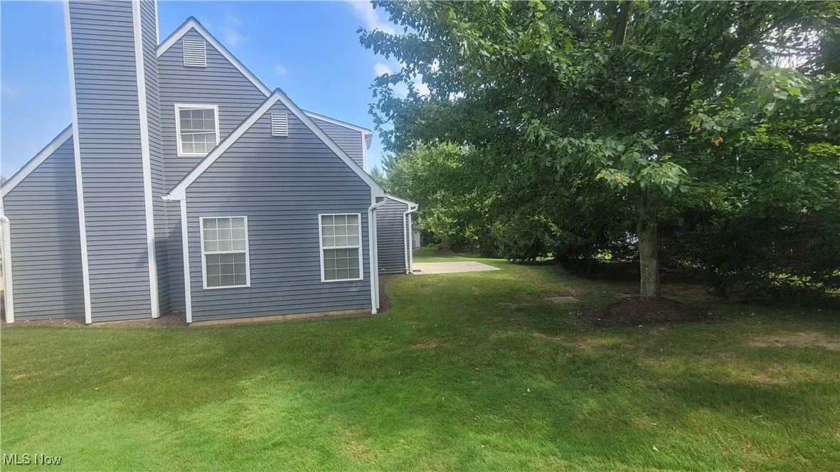 View of side of home with a lawn and a chimney