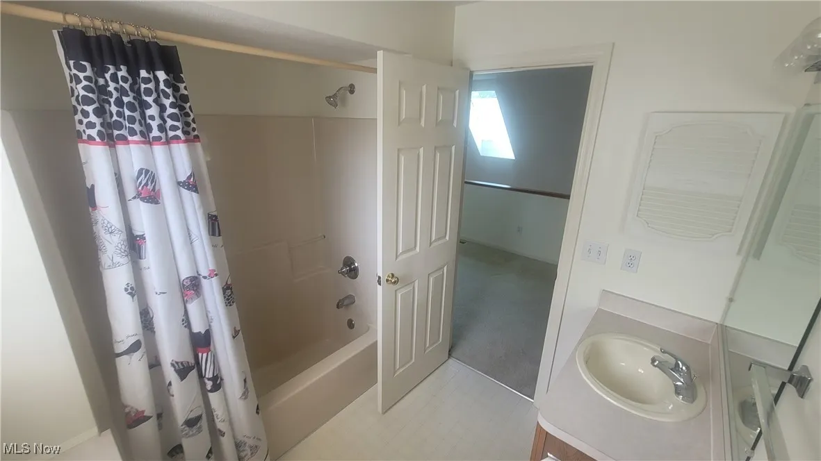 Full bath featuring shower / bath combination with curtain and vanity