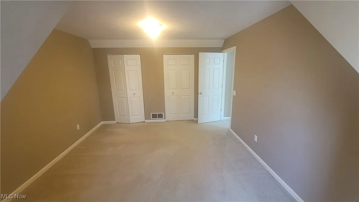 2nd floor bedroom featuring light colored carpet and baseboards