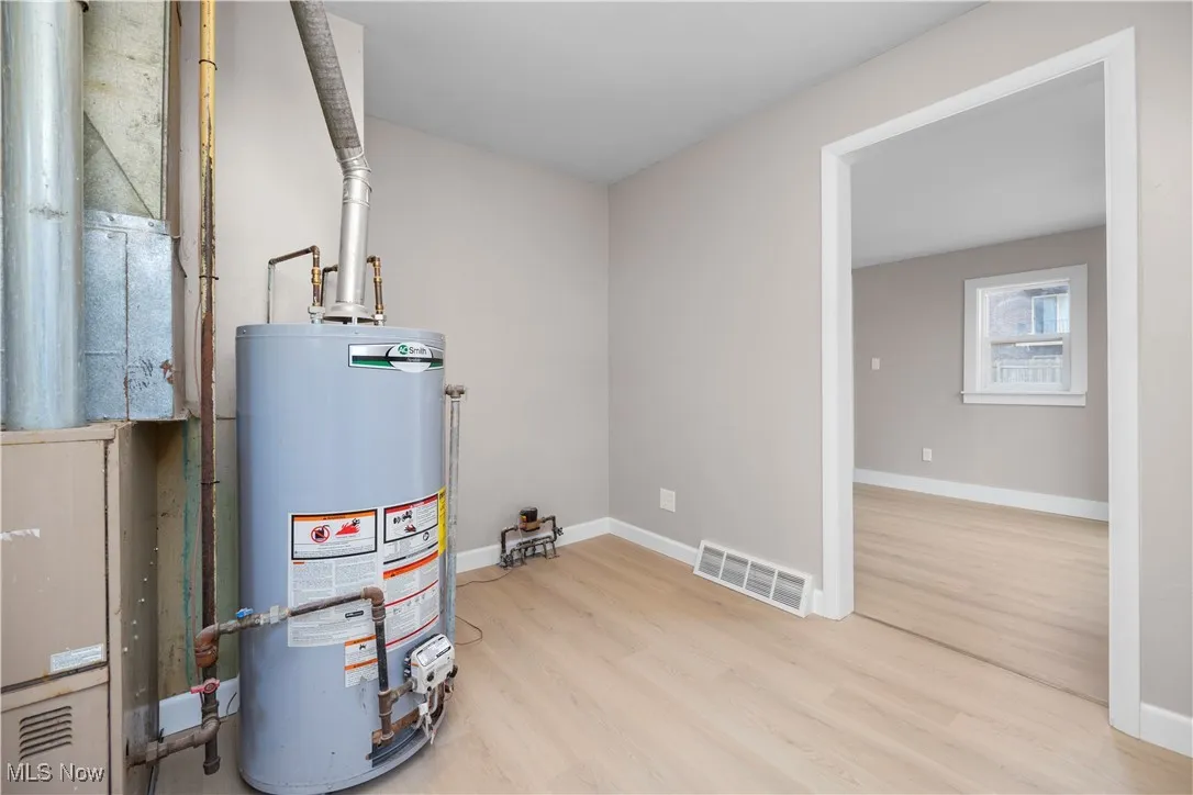 Utility room featuring gas water heater and heating unit