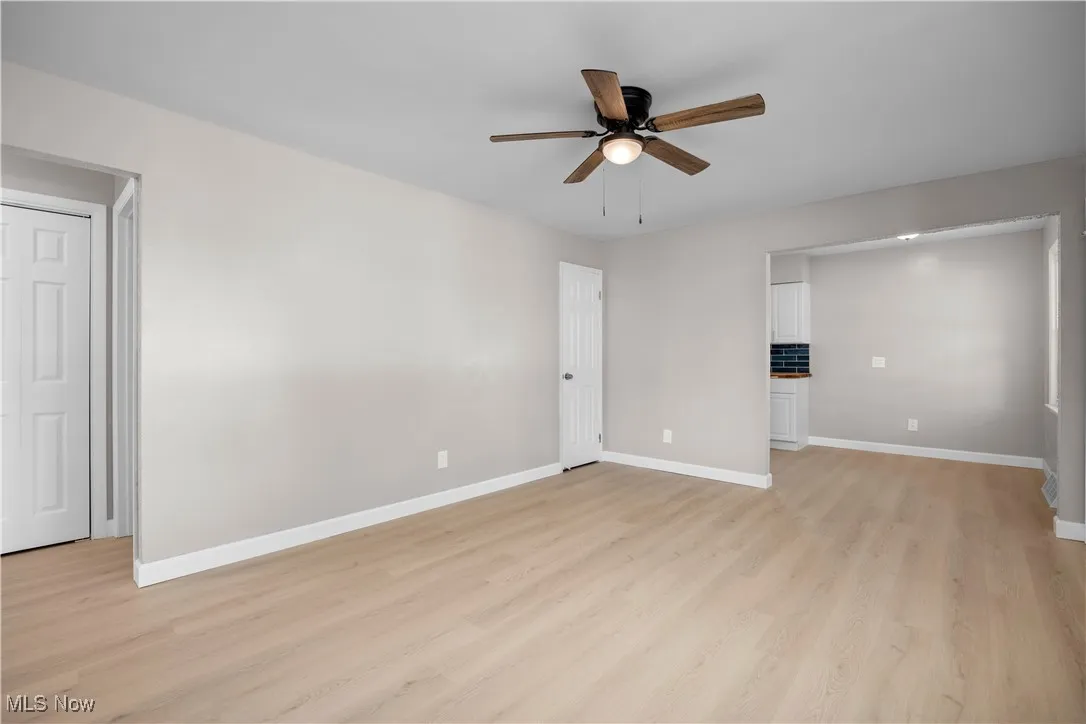 Empty room with light wood-style floors and a ceiling fan