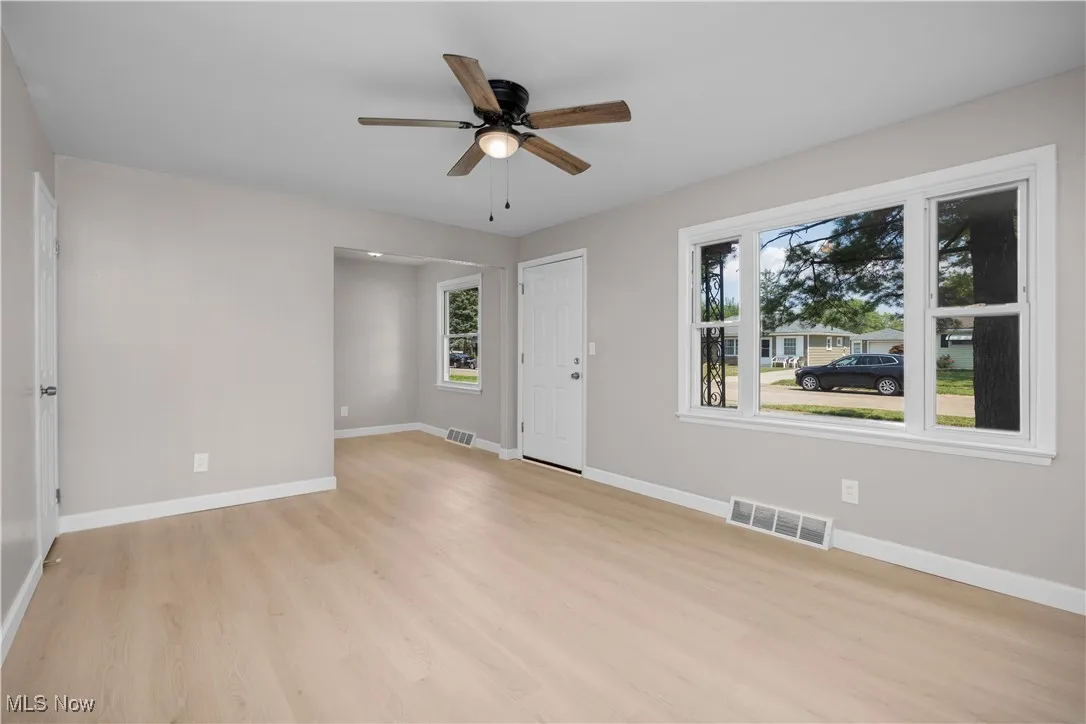 Unfurnished room with light wood finished floors and a ceiling fan