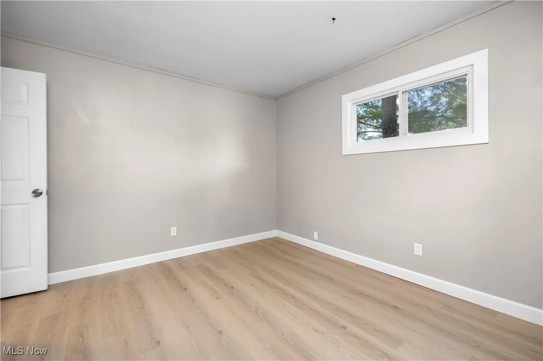 Empty room with light wood-style flooring and baseboards