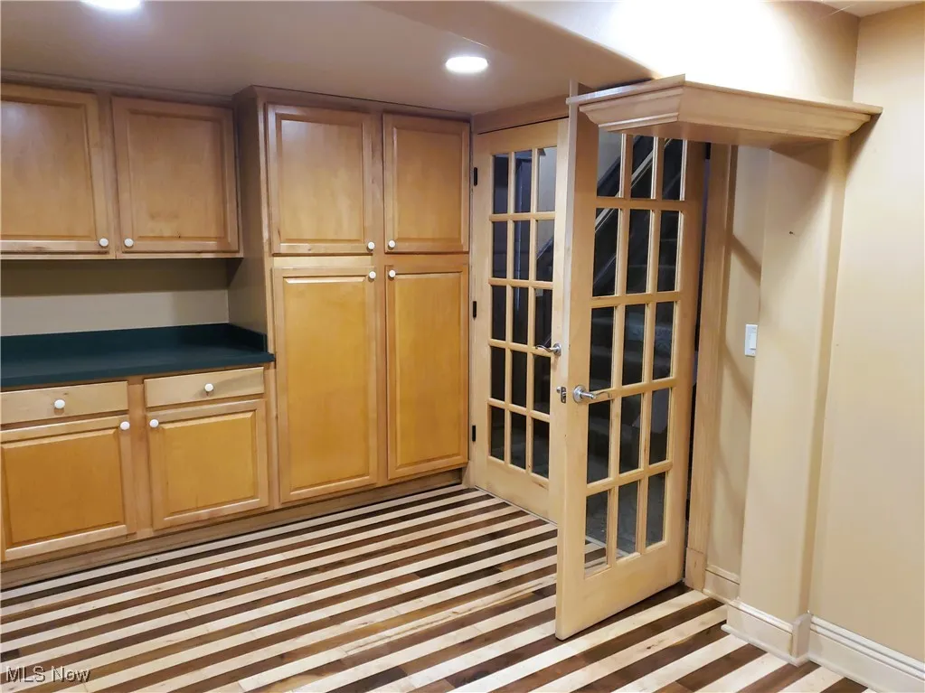 Kitchen with dark countertops, inlaid floor details, and recessed lighting