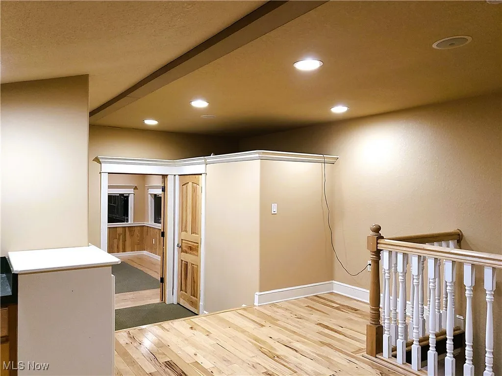 Hall featuring recessed lighting, light wood-style floors, and a barn door