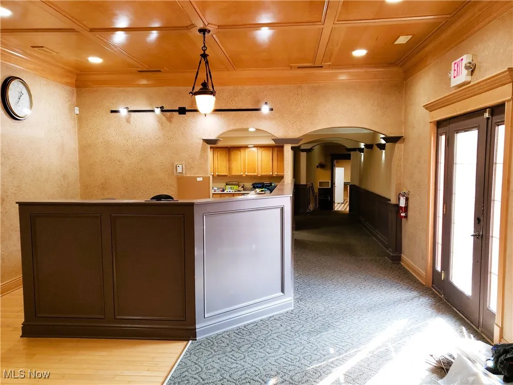 Reception with arched walkways, a textured wall, crown molding, recessed lighting, and coffered ceiling