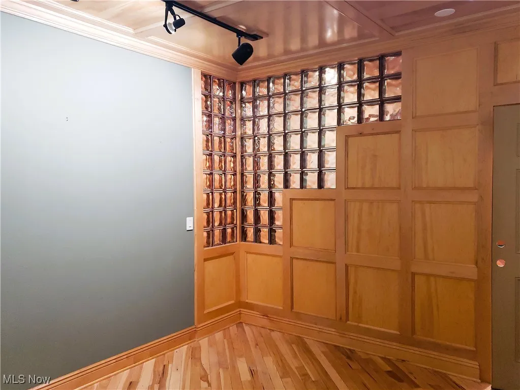 Wine area with track lighting and light wood-type flooring