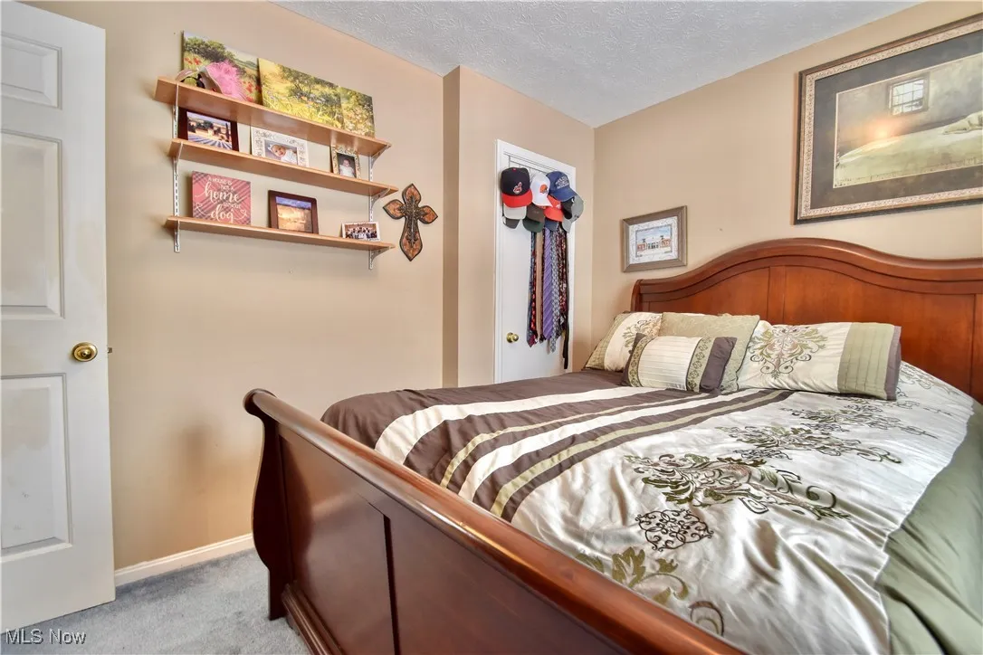 Carpeted bedroom with a textured ceiling and baseboards