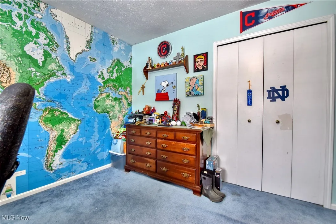 Bedroom featuring carpet floors, a textured ceiling, and a closet