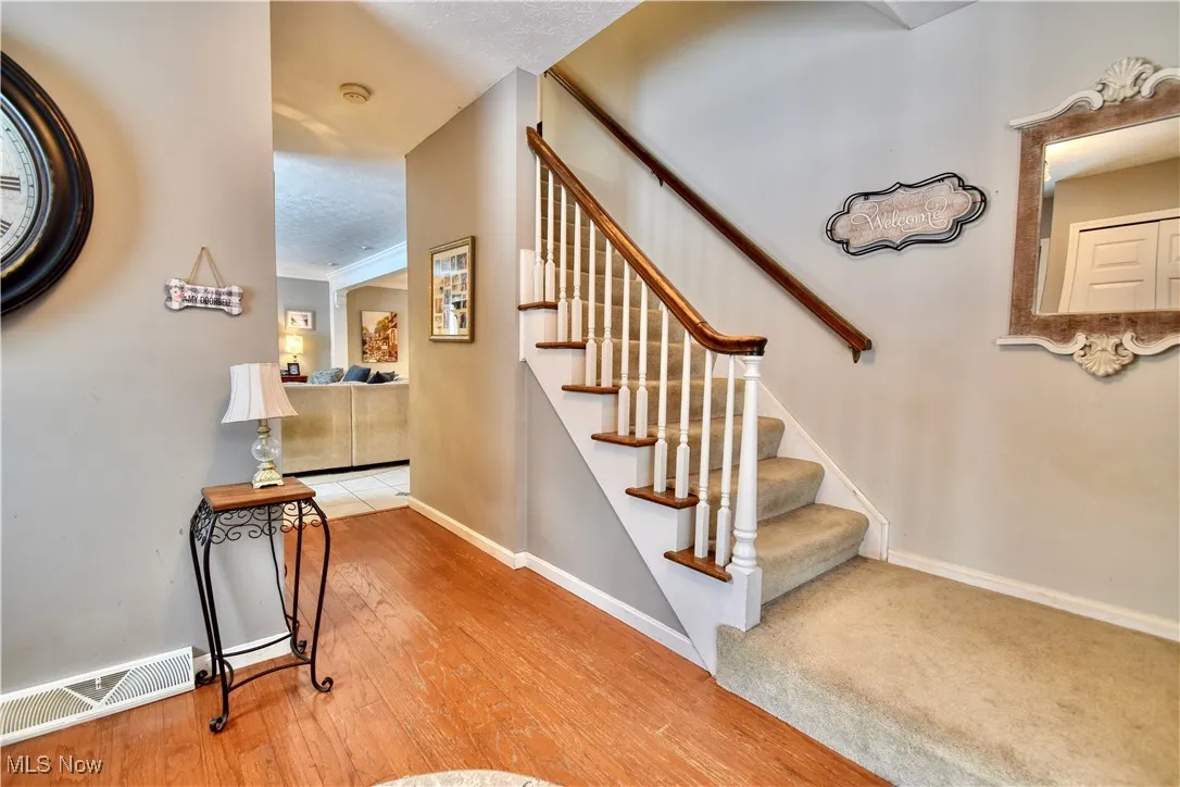 Stairway with wood-type flooring and a textured ceiling