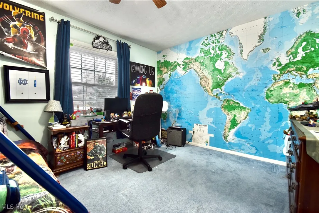Carpeted office space featuring a textured ceiling and ceiling fan