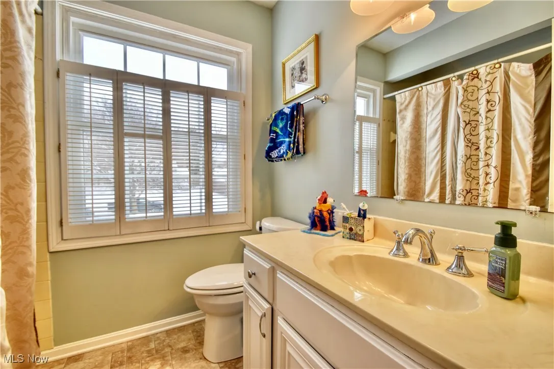 Full bath featuring plenty of natural light, vanity, and a shower with shower curtain