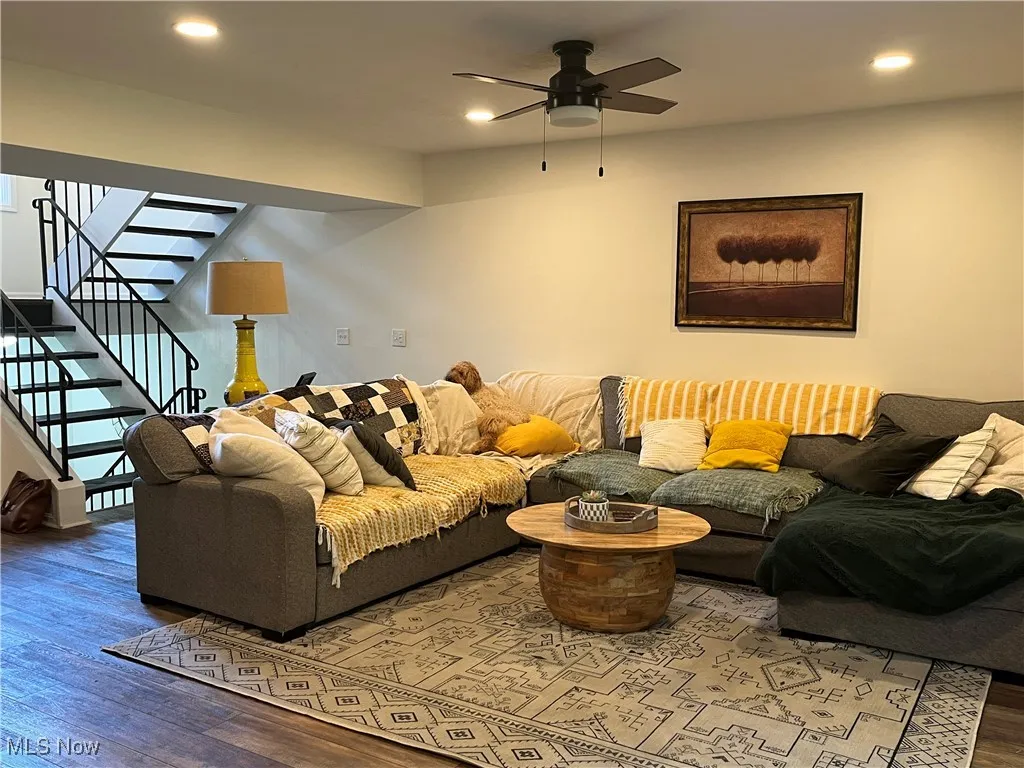 Living area on the main floor features recessed lighting, wood finished floors, stairs, and a ceiling fan