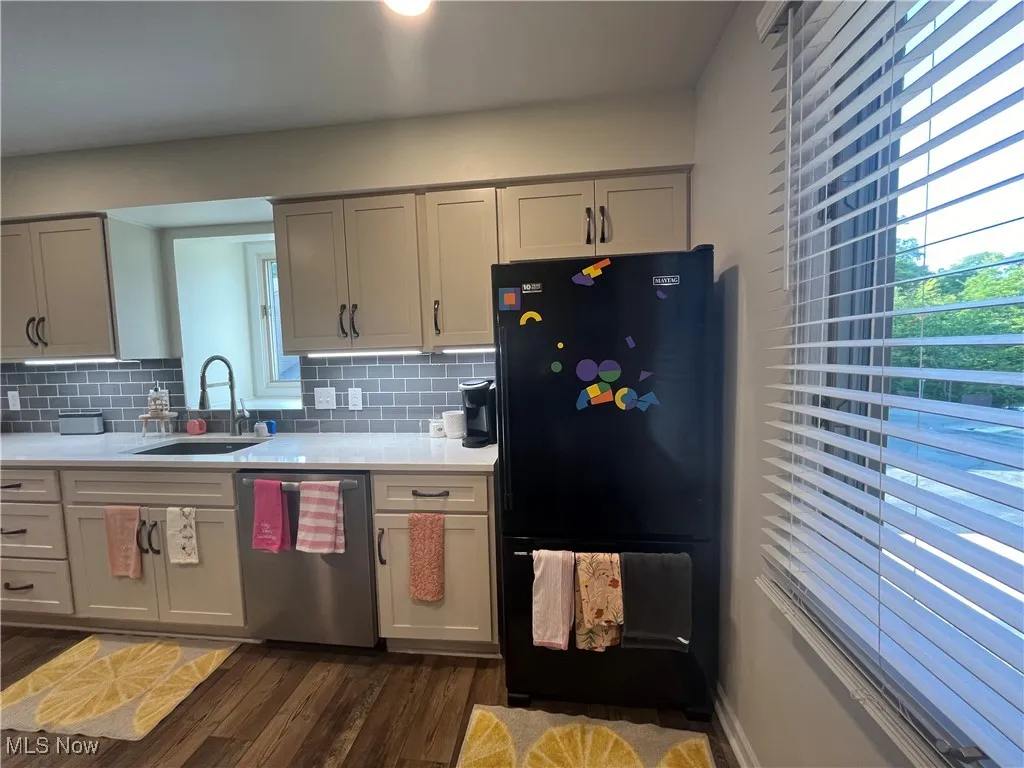 Kitchen features refrigerator, stainless steel dishwasher, Quartz countertops, and decorative backsplash