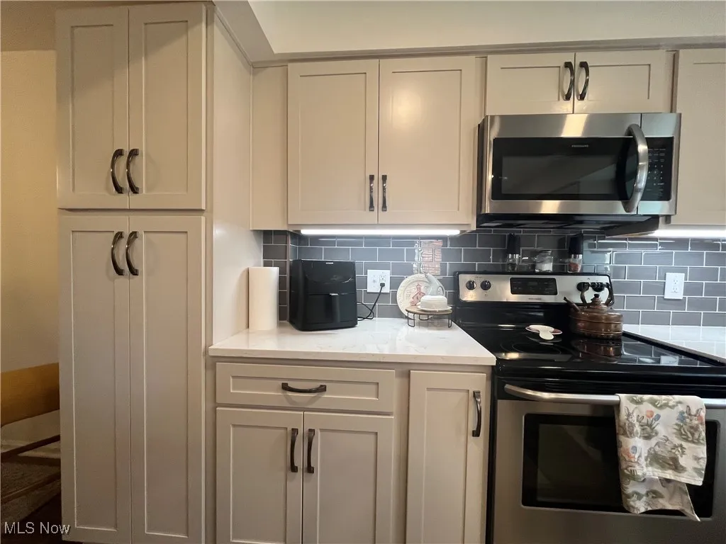 Kitchen features Kraftmaid cabinets, Quartz countertops, Subway Tite Backsplash and appliances with stainless steel finishes.