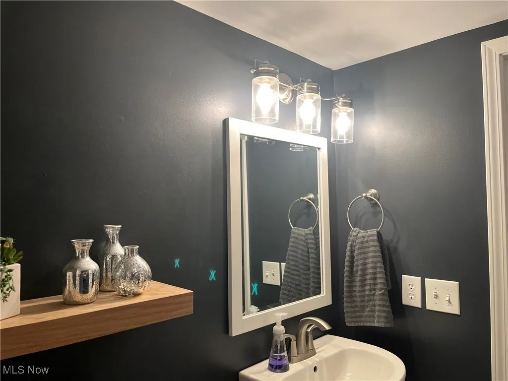 Half Bathroom has modern mirror and light fixture.