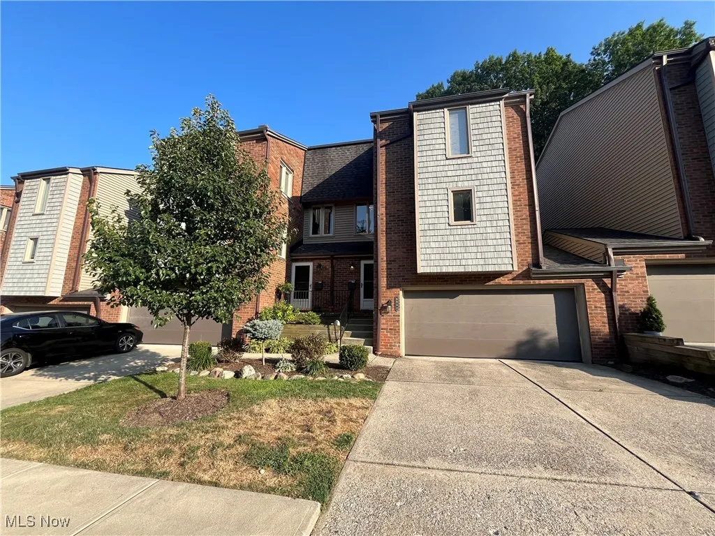 View of the front of Townhouse with a 2-car attached garage, concrete driveway, and brick siding.