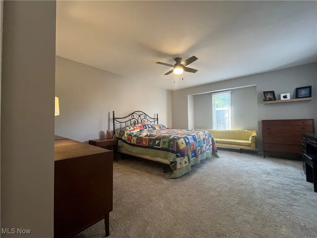 Primary Bedroom featuring new carpeting and a ceiling fan light.