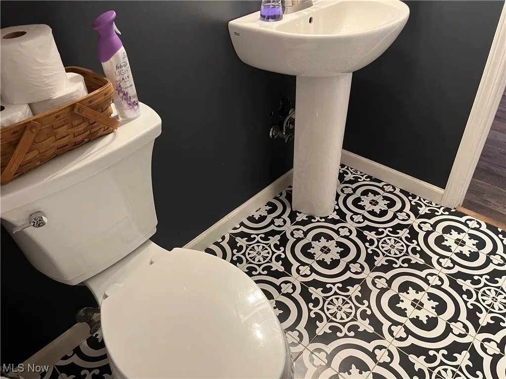 Half bathroom with patterned ceramic file floor.