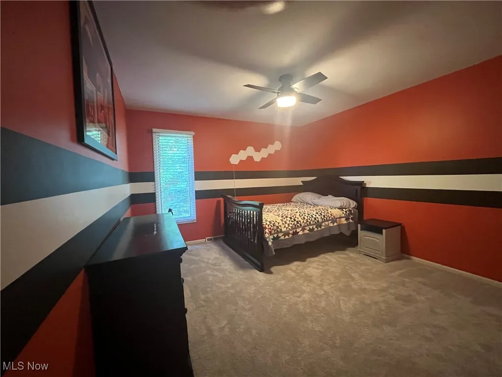 Carpeted bedroom with a ceiling fan light.  Go Browns !!