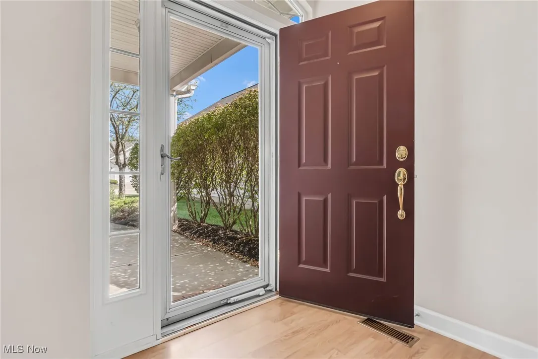 Doorway with wood finished floors and baseboards