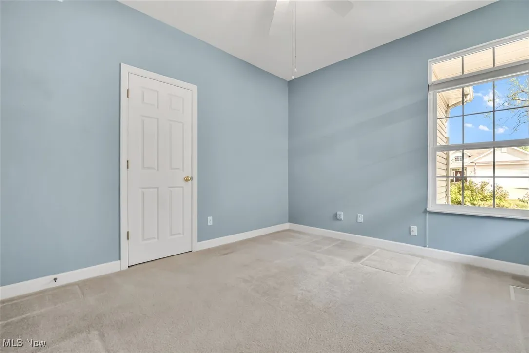 Carpeted spare room featuring baseboards and ceiling fan