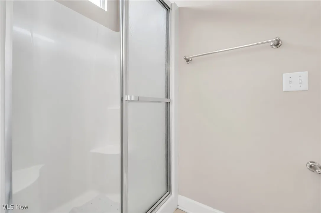 Bathroom with a stall shower and baseboards