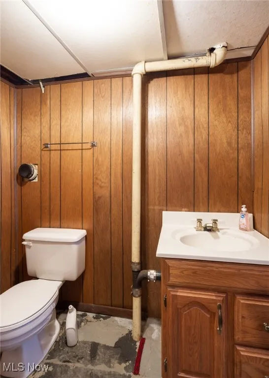 Half bathroom featuring vanity and toilet