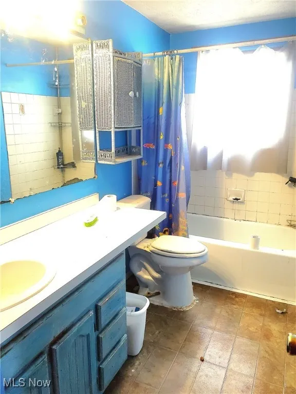 Bathroom with shower / bath combo with shower curtain and vanity
