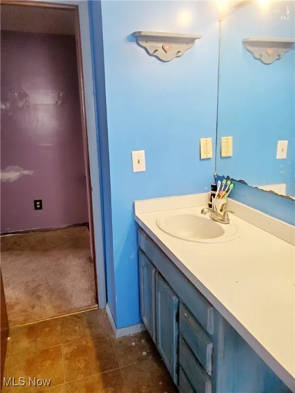 Bathroom featuring vanity and dark tile patterned flooring